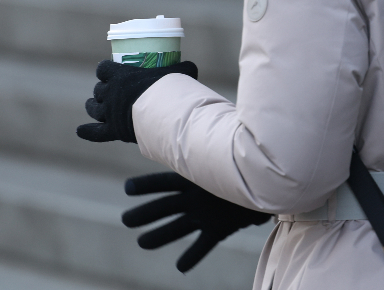 A Seoulite walks with a cup of coffee in her hand on Jan. 8. (Yonhap)