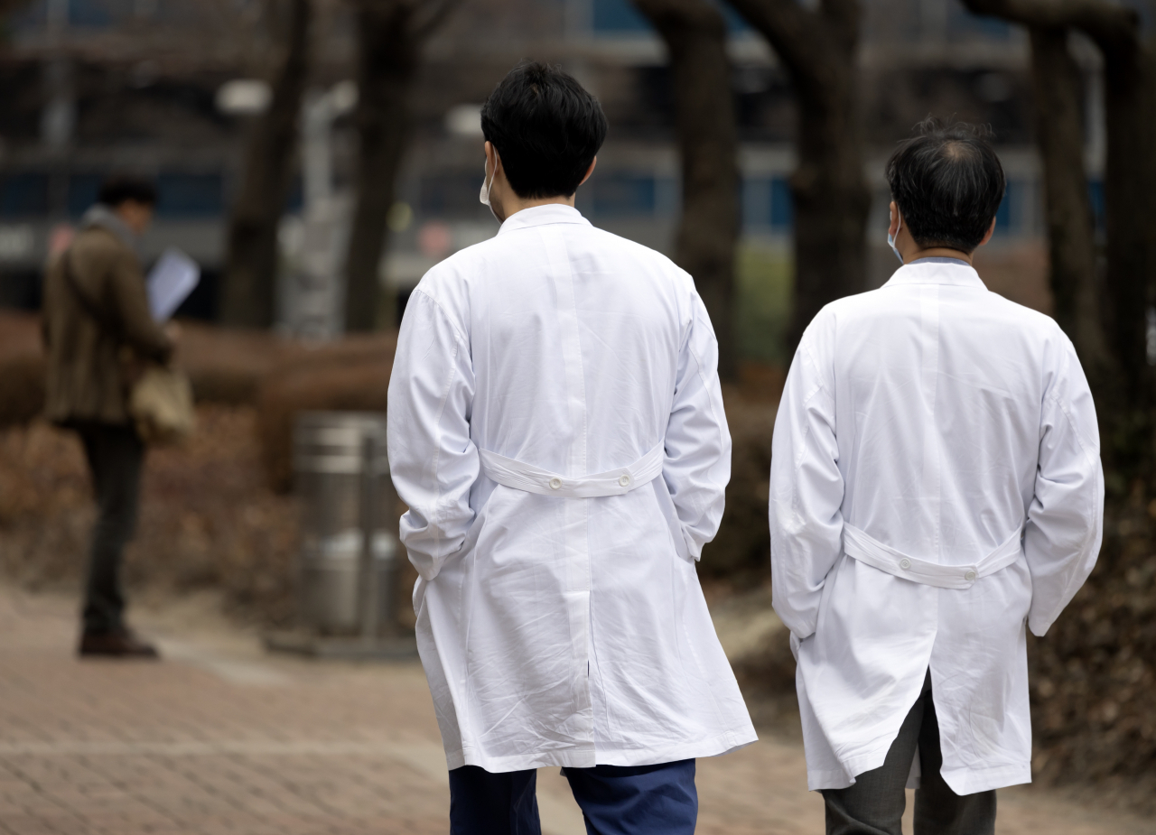 Doctors walk outside a hospital in Seoul, Tuesday. (Yonhap)