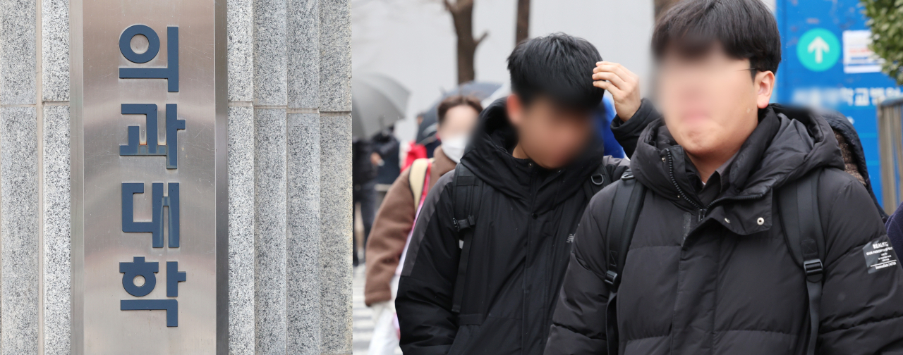 Students walk by the College of Medicine at a university in Seoul on Feb. 5. (Yonhap)