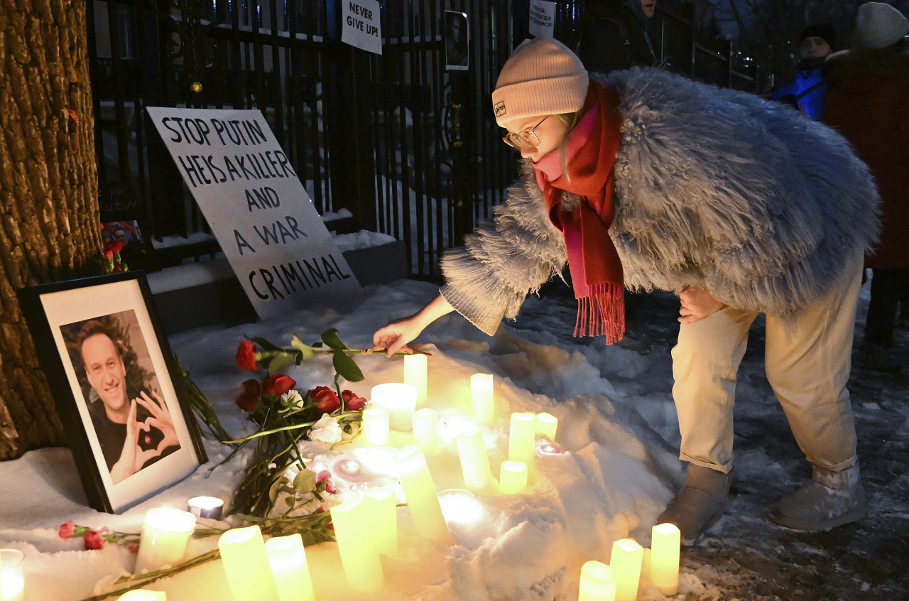 A person places a flower at a makeshift memorial for Alexei Navalny outside the Russian consulate in Montreal, Friday. (AP-Yonhap)