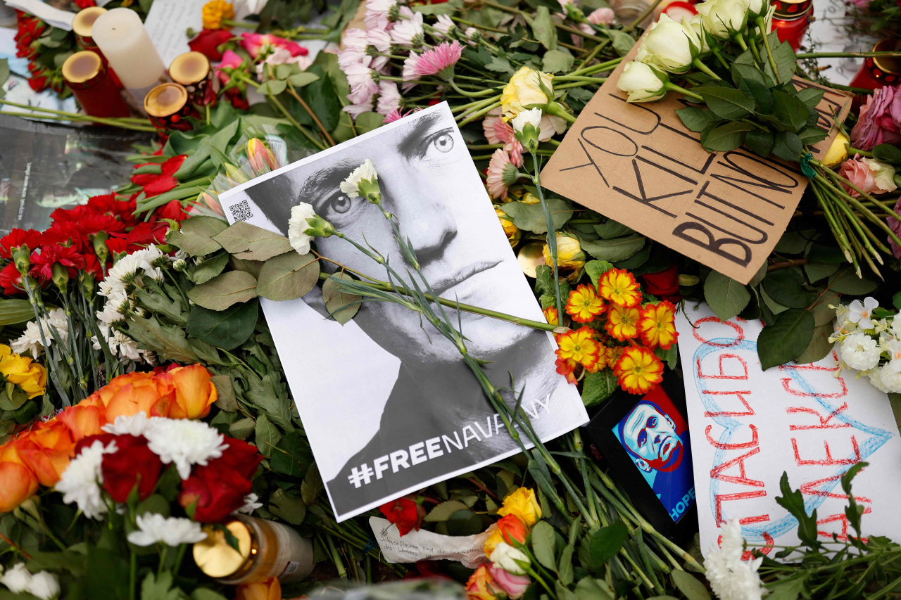 Flowers are laid upon a memorial in front of the Russian embassy in Berlin, Sunday, following the death of the Kremlin's most prominent critic Alexei Navalny in an Arctic prison. (AFP-Yonhap)