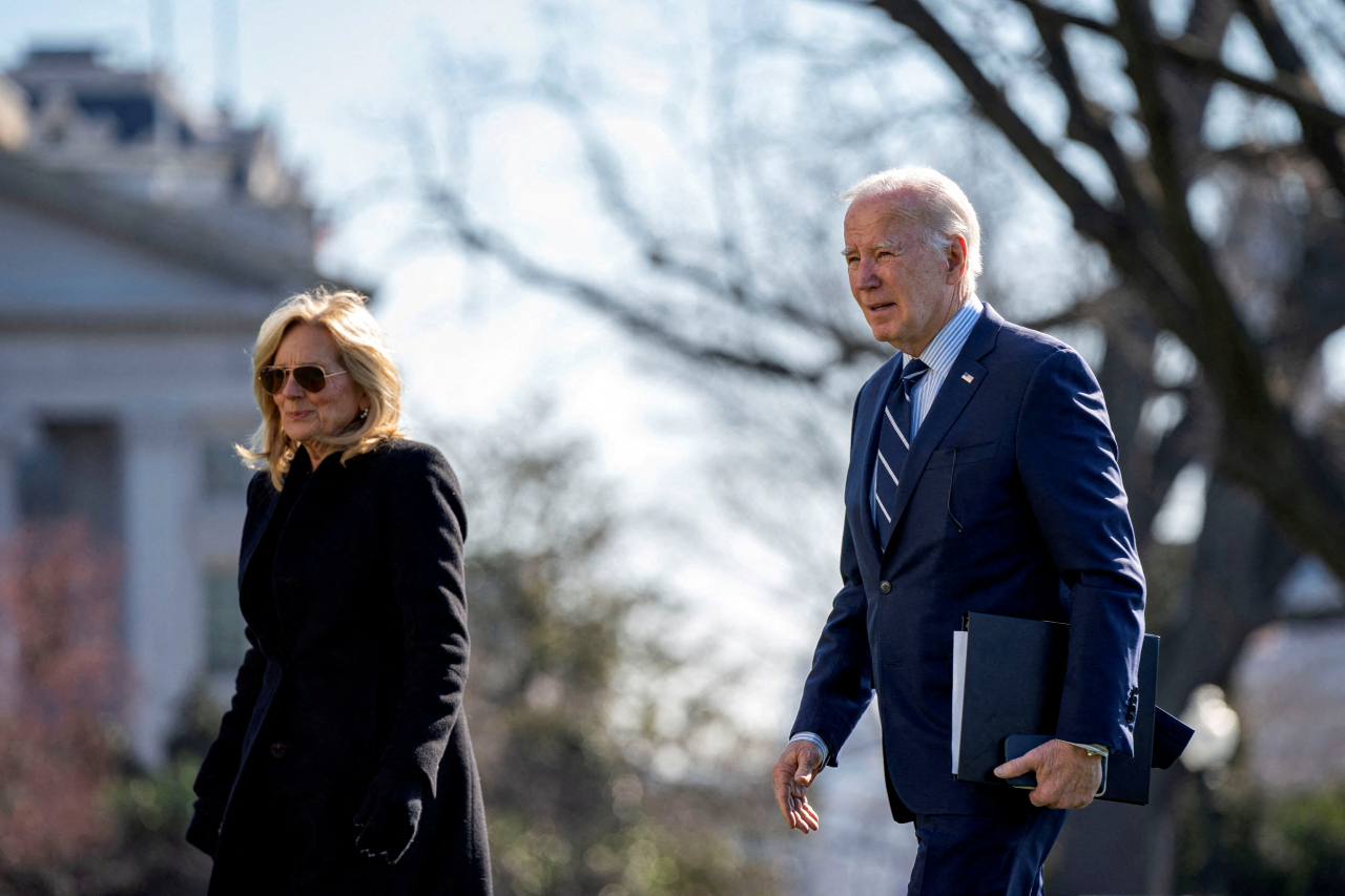 US President Joe Biden and First Lady Jill Biden walk across the South Lawn of the White House, on his return from a weekend trip to Delaware, in Washington, US, Tuesday. (Reuters-Yonhap)