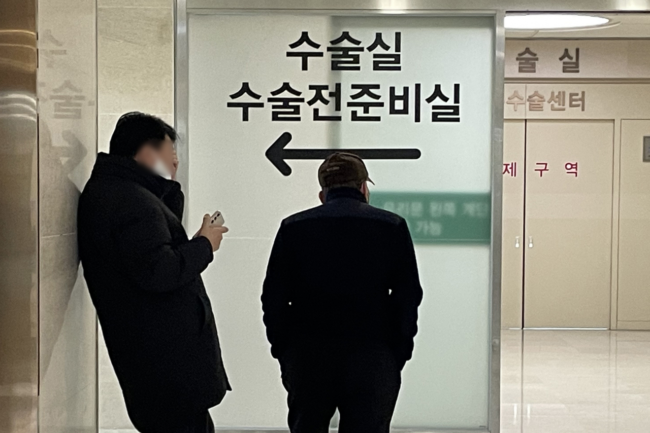 People wait in front of a surgery room at a hospital in Seoul, Wednesday. (Yonhap)