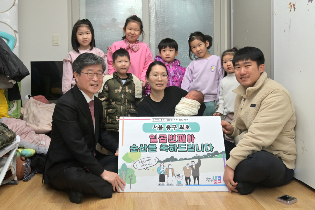 Jeon Hye-hee (center) and her husband Jo Yong-seok (right) pose with Jung-gu Office chief Kim Gil-sung at the couple's home on Wednesday, after receiving 10 million won ($7,500) for having multiple children. (Jung-gu Office)