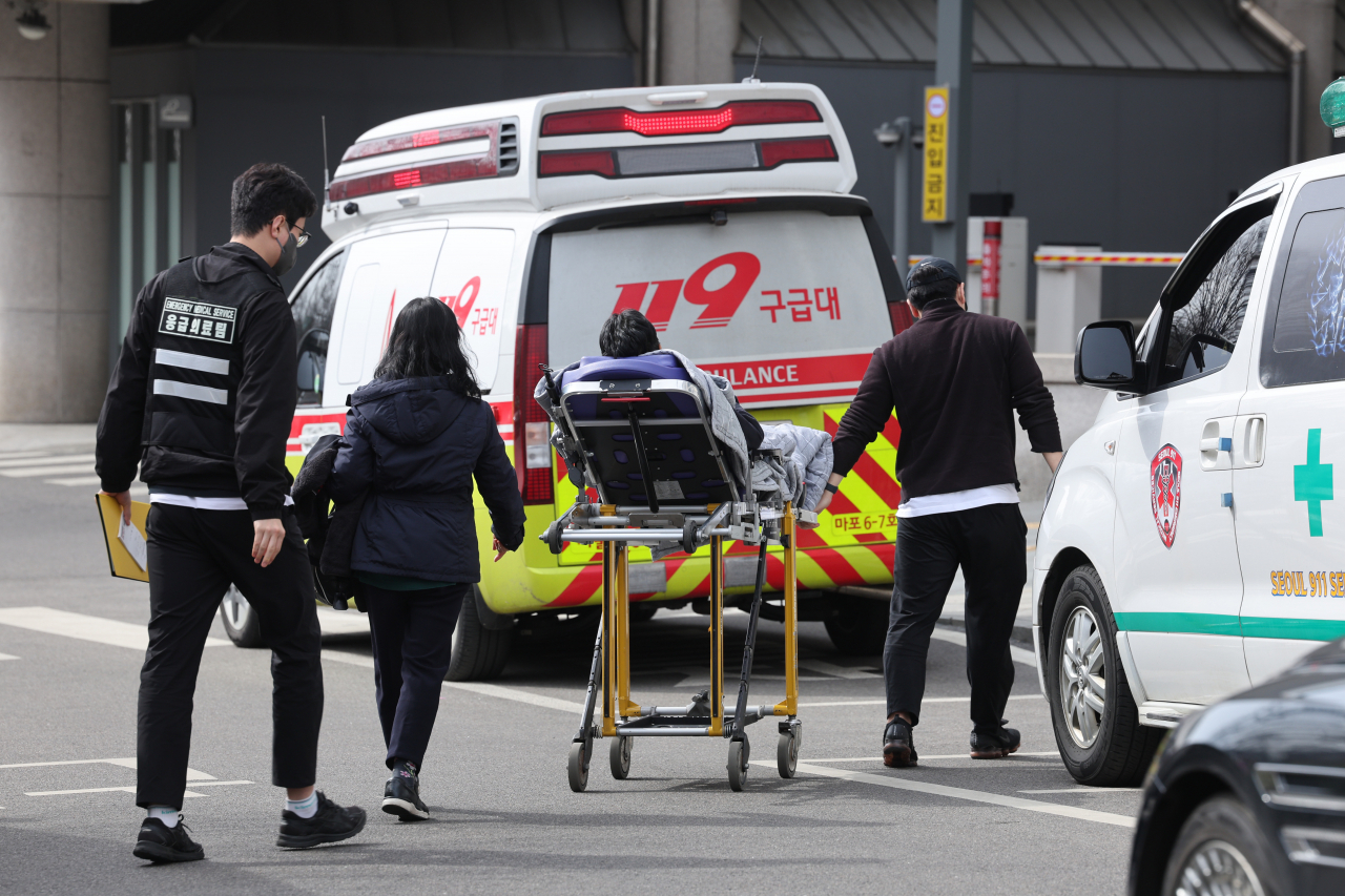 A patient is transported to the emergency room in Seoul on Saturday amid a walkout by trainee doctors protesting the government's plan to increase the medical school enrollment quota. (Yonhap)