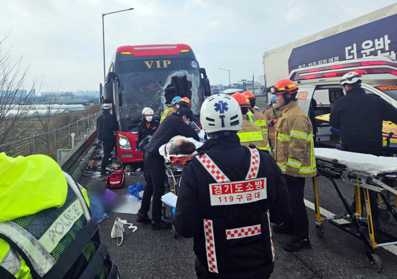 Rescue workers move those injured by an accident involving a semi-trailer truck and a bus at the Gyeongbu Expressway on Sunday. (Yonhap)