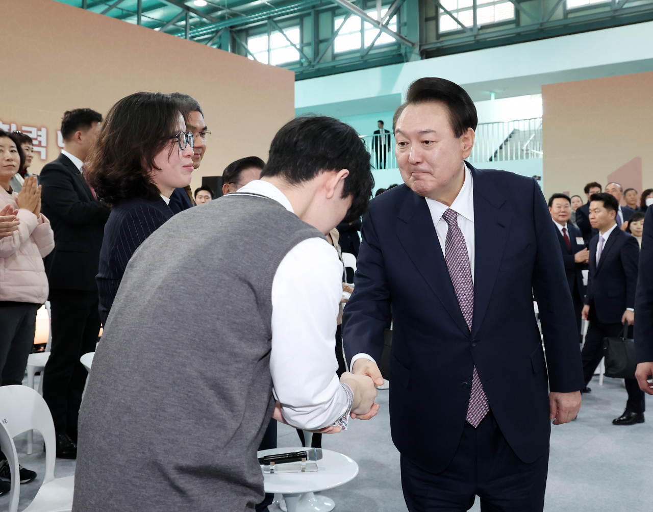 President Yoon Suk Yeol (right) shakes hand with a participant in a policy debate held at Seosan Air Base in Seosan, South Chungcheong Province, on Monday, (Pool photo via Yonhap)