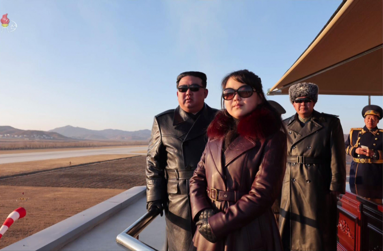 North Korean leader Kim Jong-un (left and rear), alongside his daughter, believed to be named Ju-ae (front), watches a demonstration flight by the country's airmen during his visit to a flight regiment of the North Korean Air Force on Nov. 30, 2023. The photo was aired by North Korea's state-run Korean Central Television the following day. (Newsis)