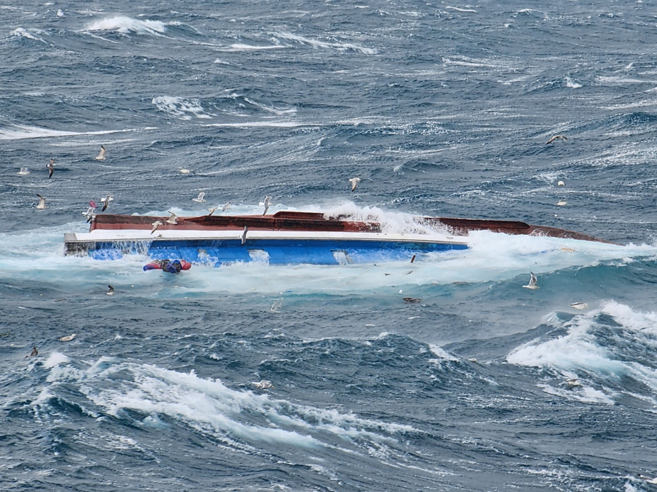 This image provided by the Coast Guard shows a fishing boat that capsized in waters off the southern island of Jeju on Friday. (Yonhap)