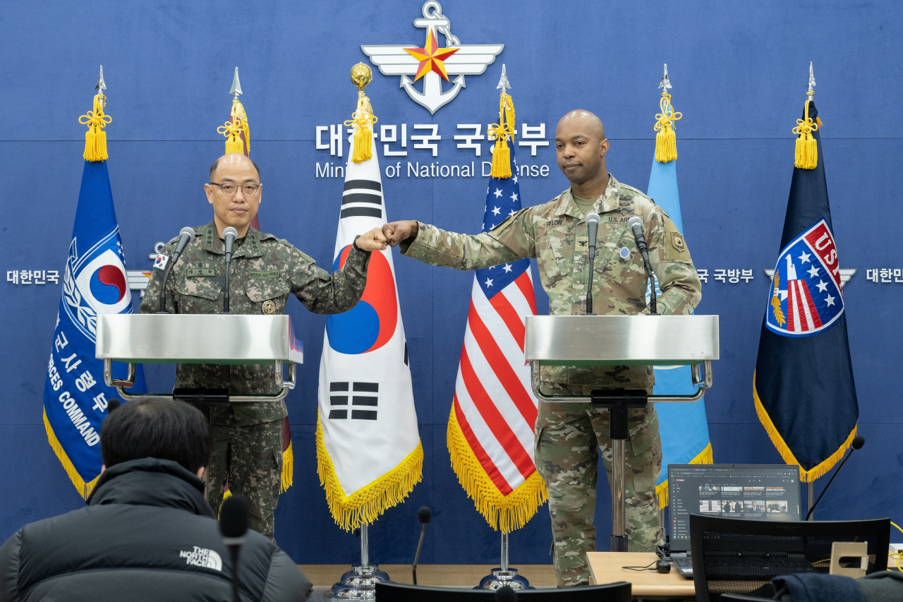 Col. Lee Sung-jun, the Joint Chiefs of Staff's spokesperson, bumps fists with Col. Issac Taylor, spokesperson of the US Forces Korea, in a press briefing at the defense ministry's headquarters in central Seoul on Wednesday. (Yonhap)