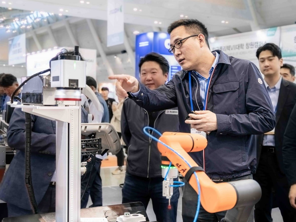 Kim Dong-seon, vice president of Hanwha Hotel & Resorts and Hanwha Robotics, looks at a cooperative robot at a tech trade show in Seoul. (Hanwha Robotics)