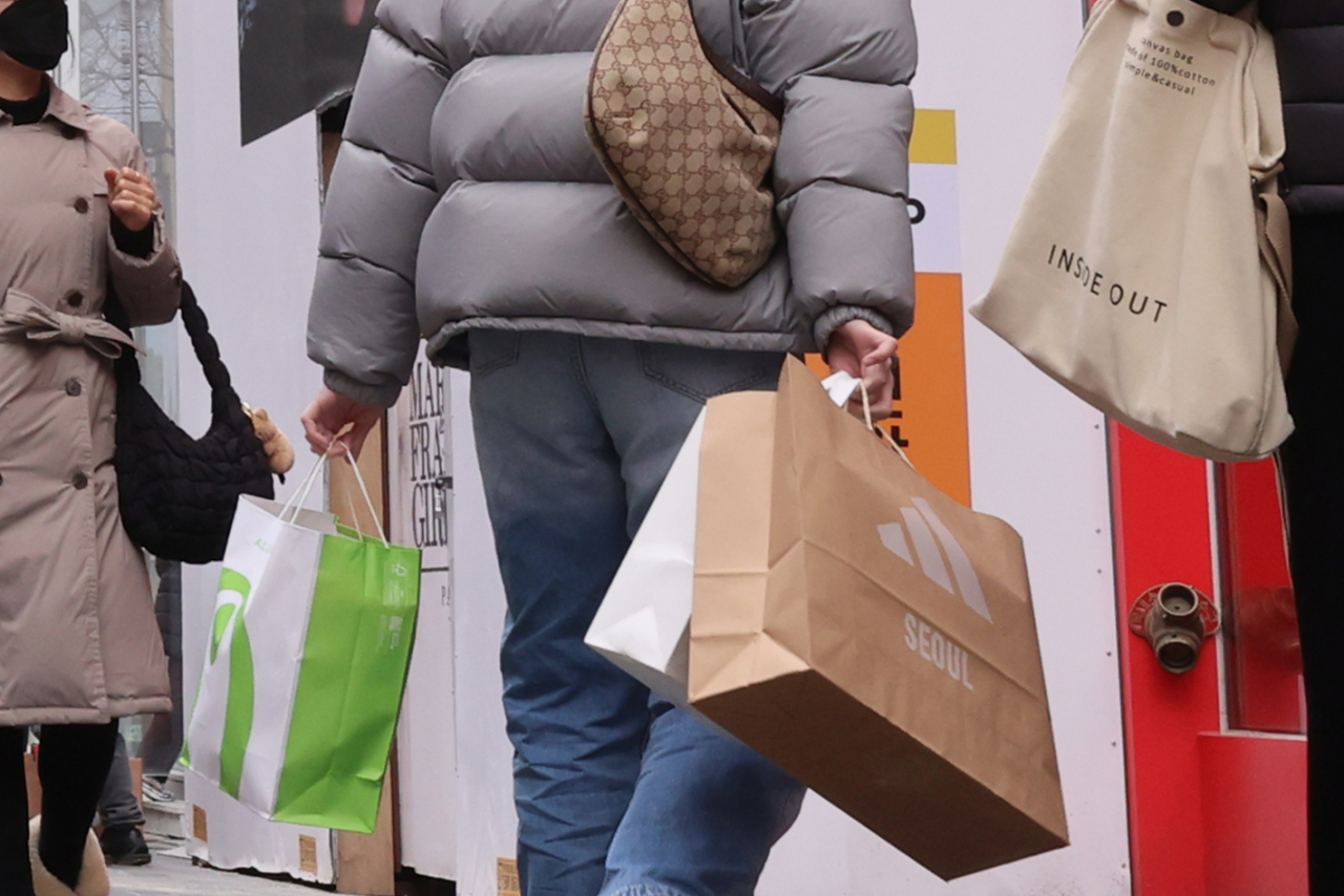 A passerby walks with shopping bags in the Myeongdong area, central Seoul on Tuesday. (Yonhap)