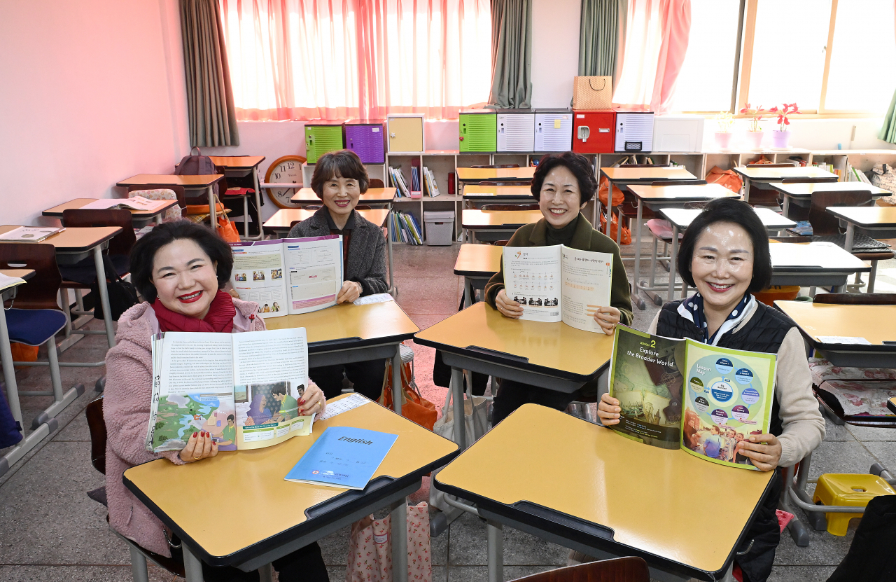 Clockwise from bottom right: Lee Bok-ja, Kim Jeong-ja, Sung Ok-ja and Yoo Ae-ran pose for a photograph in their classroom at Ilsung Women’s Middle and High School on Feb. 14. (Lee Sang-sub/The Korea Herald)