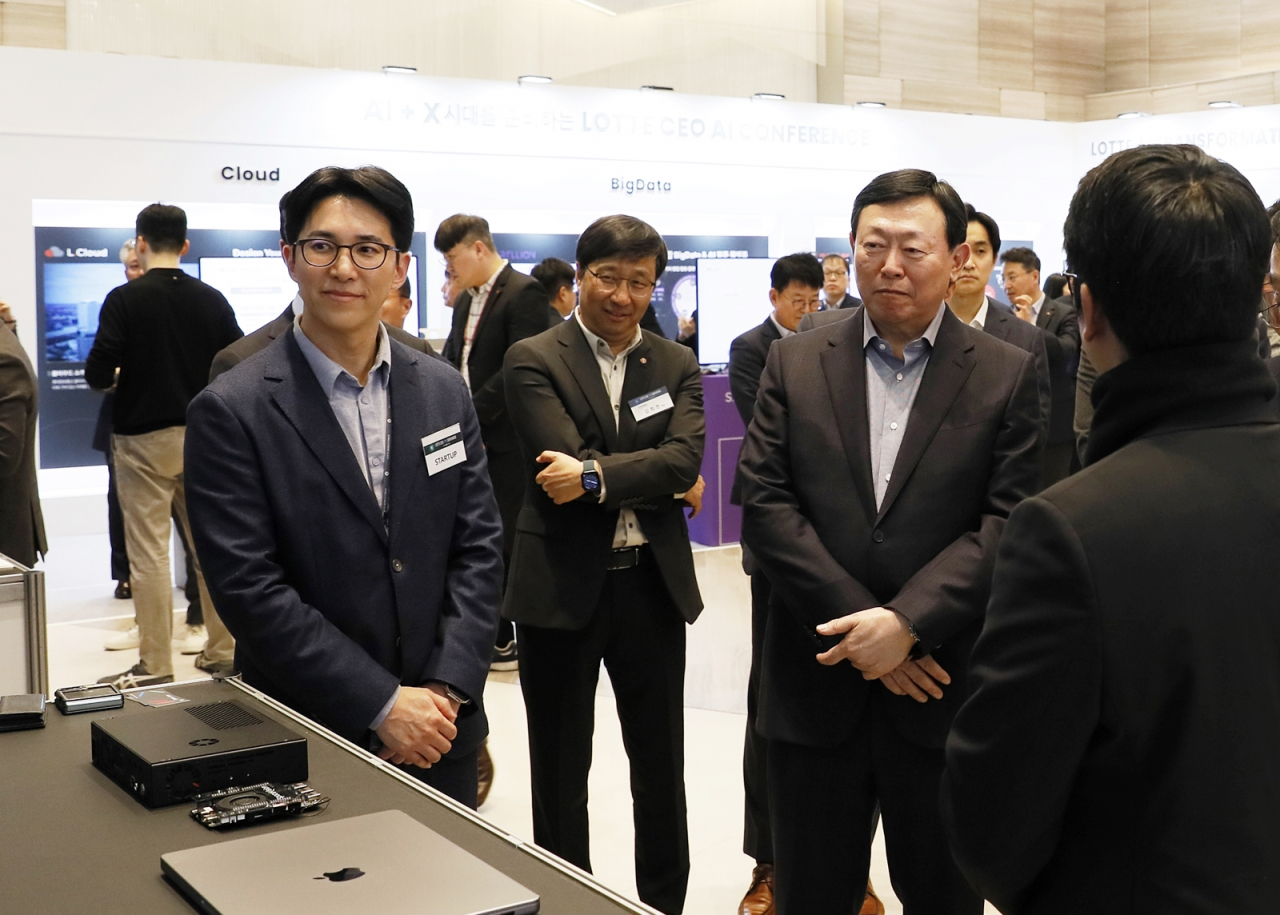 Lotte Group Chair Shin Dong-bin (third from left) is listening to a local AI startup firm CEO's presentation at the group's AI conference held at Lotte World Tower on Thursday. (Lotte Group)