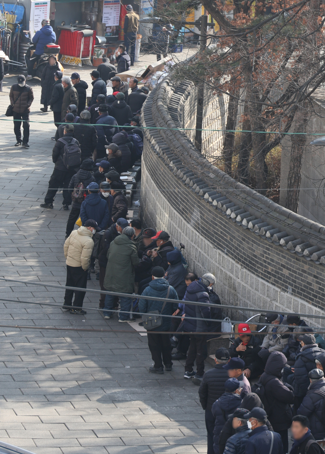 People are waiting in line at a soup kitchen in Jongno-gu, central Seoul in this Feb.12 file photo. (Yonhap)