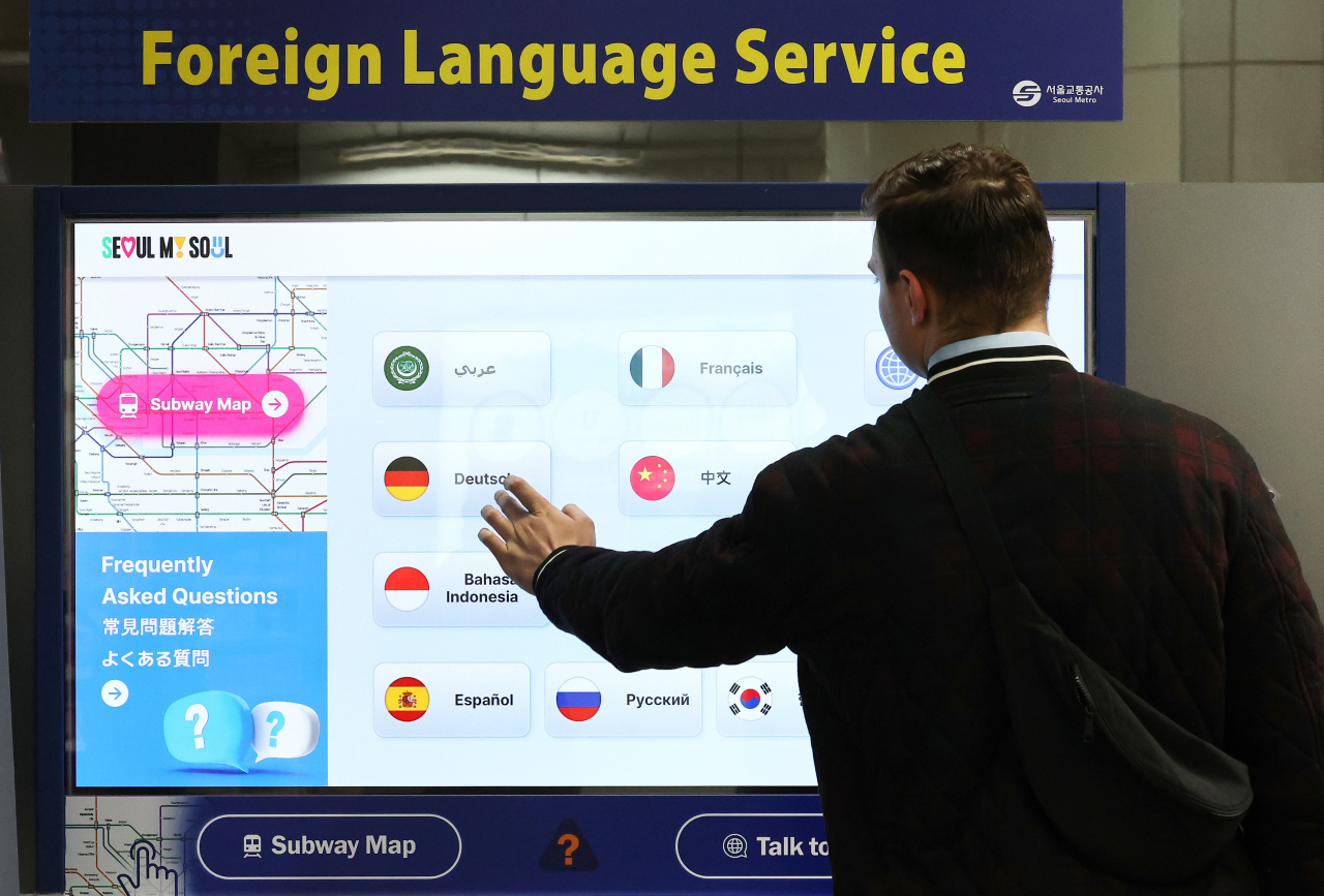 A traveler uses Seoul Metro's artificial intelligence-powered translation service at Gwanghwamun Station on Thursday. (Yonhap)