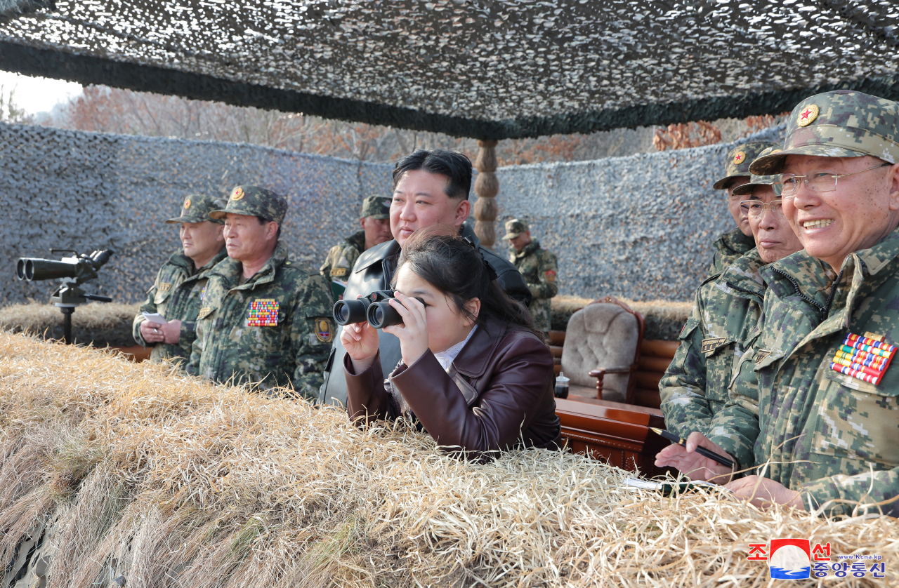 This photo, carried by North Korea's official Korean Central News Agency on Saturday shows the North's leader Kim Jong-un (left) and his daughter, believed to be named Ju-ae, guiding military drills of air-borne units of the Korean People's Army the previous day. (Yonhap)