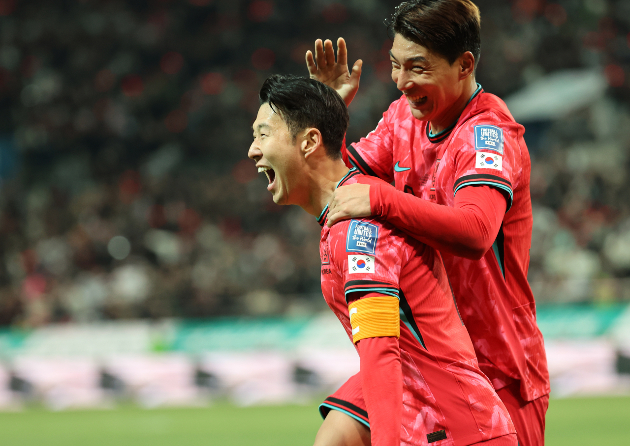 Son Heung-min of South Korea (left) celebrates after scoring against Thailand during the teams' Group C match in the second round of the Asian World Cup qualification tournament at Seoul World Cup Stadium in Seoul, Thursday. (Yonhap)