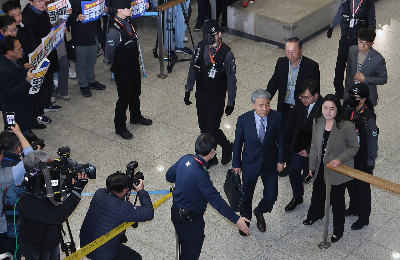 Lee Jong-sup (wearing suit and tie), the Korean ambassador to Australia, leaves a terminal at Incheon Airport after returning from Australia, Thursday. (Yonhap)