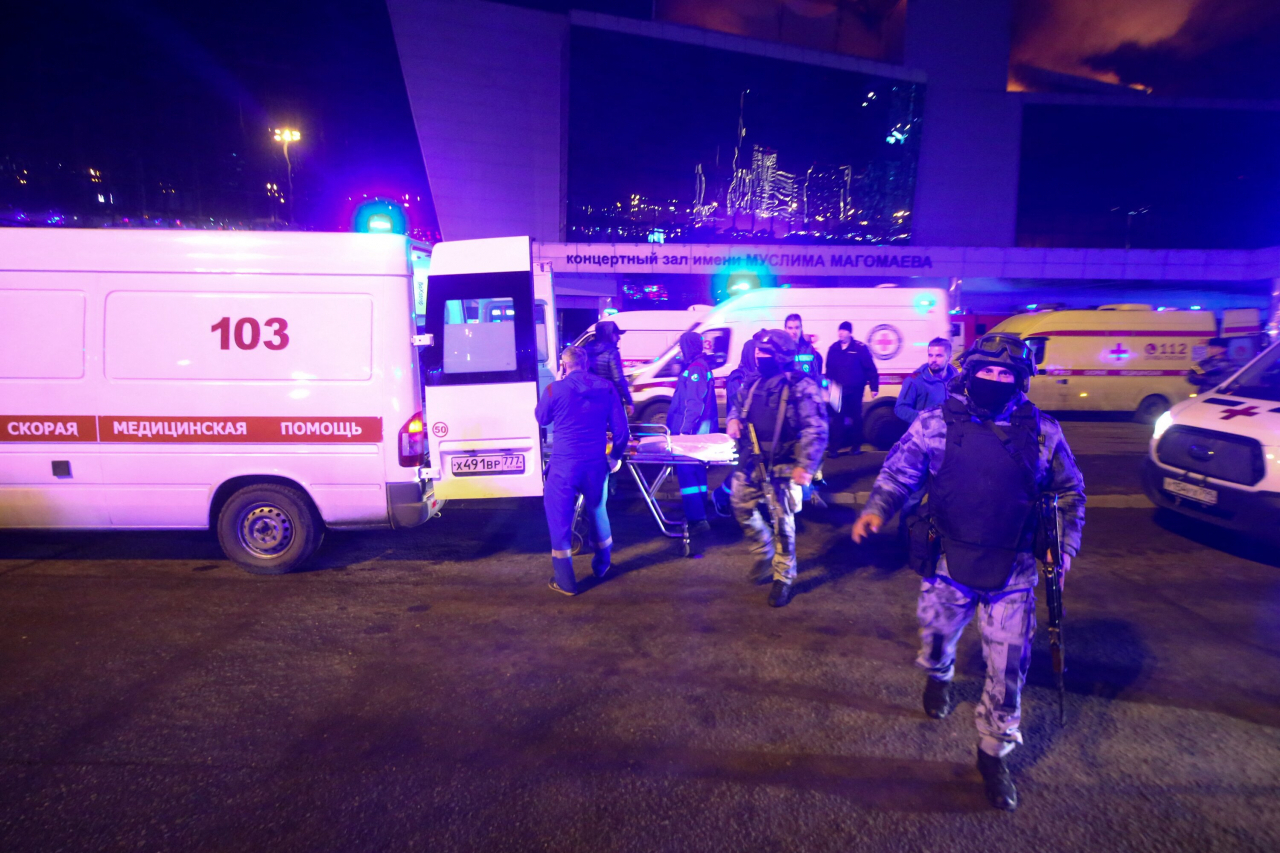 Medics and law enforcement officers are seen outside the Crocus City Hall concert hall following the shooting incident in Krasnogorsk, outside Moscow, on Friday. (AFP-Yonhap)