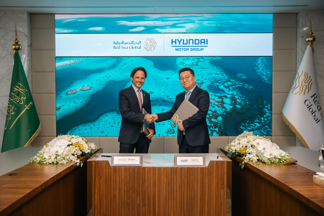Lee Dong-kun (right), vice president at Hyundai Motor Group, shakes hand with John Pagano, CEO of Red Sea Global, after signing a memorandum of understanding to cooperate in introducing future mobility solutions to Saudi Arabia's Red Sea luxury resorts development project, in Riyadh on Sunday. (Hyundai Motor Group)