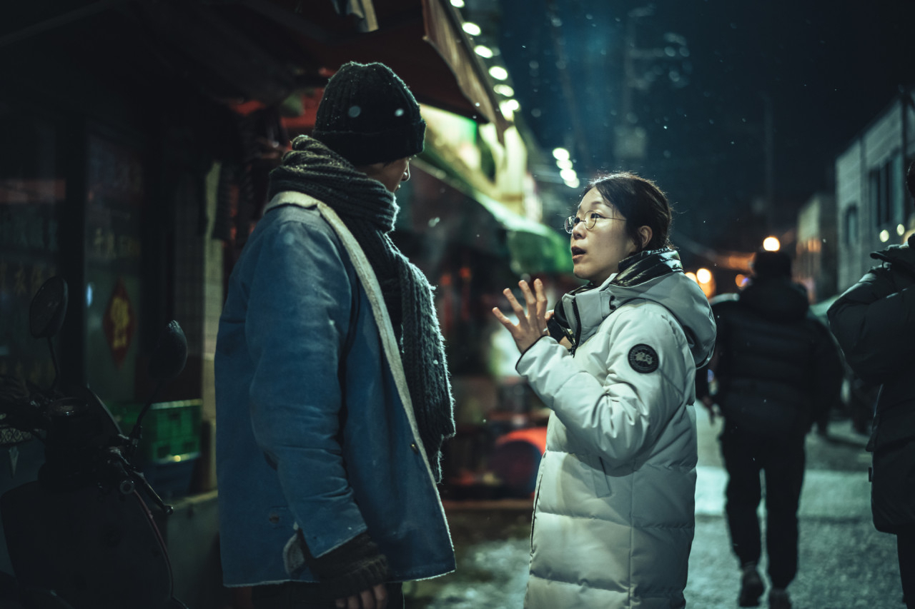 Actor Song Joong-ki (left) and director Kim Hee-jin (right) chat during the shooting of “My Name is Loh Kiwan.” (Netflix)
