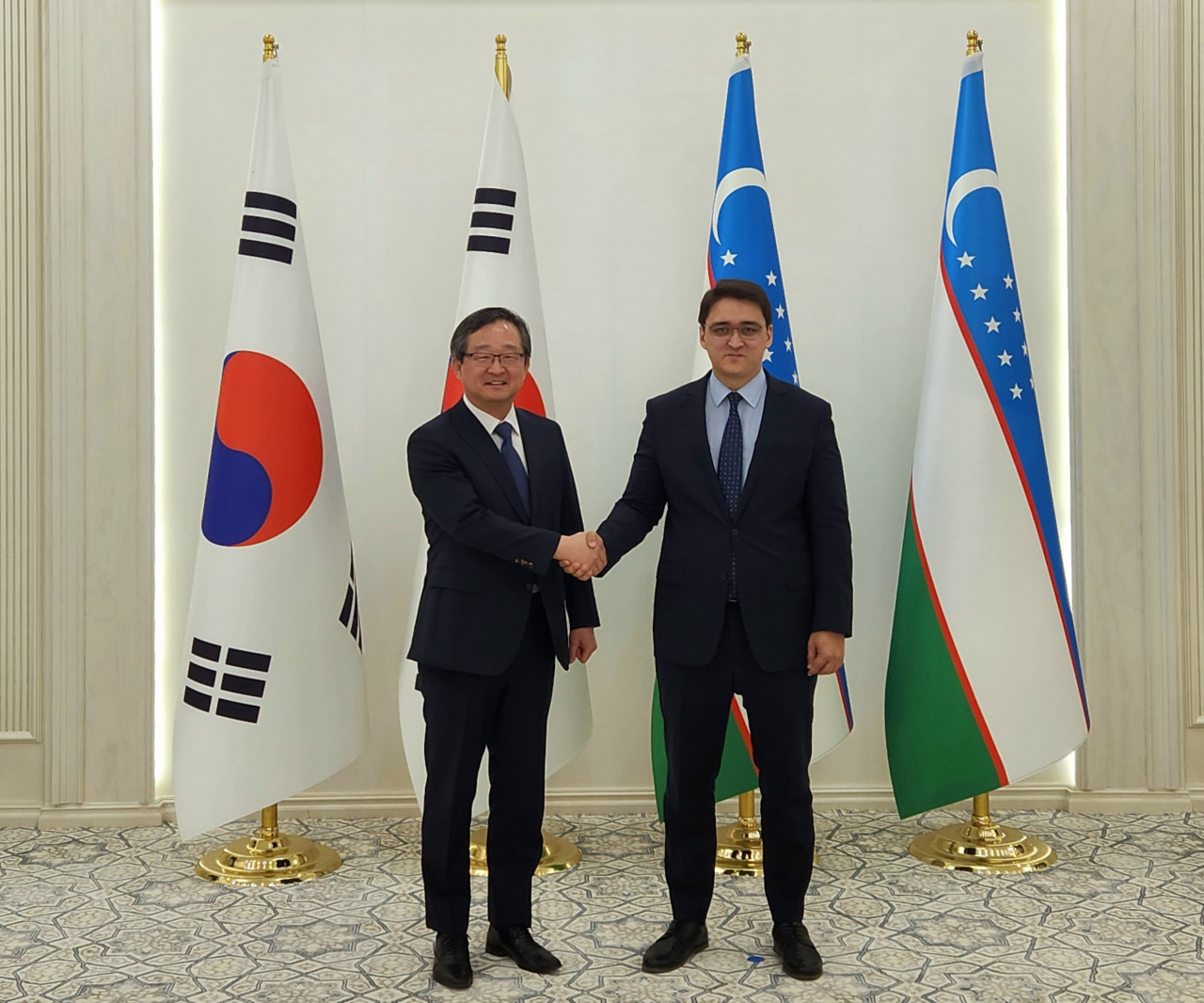 South Korean Deputy Minister for Political Affairs Chung Byung-won (left) and Uzbek Deputy Foreign Minister Bobur Usmanov shake hands during the 16th Korea-Uzbekistan Policy Consultation held on Monday in Tashkent. (South Korean Ministry of Foreign Affairs)