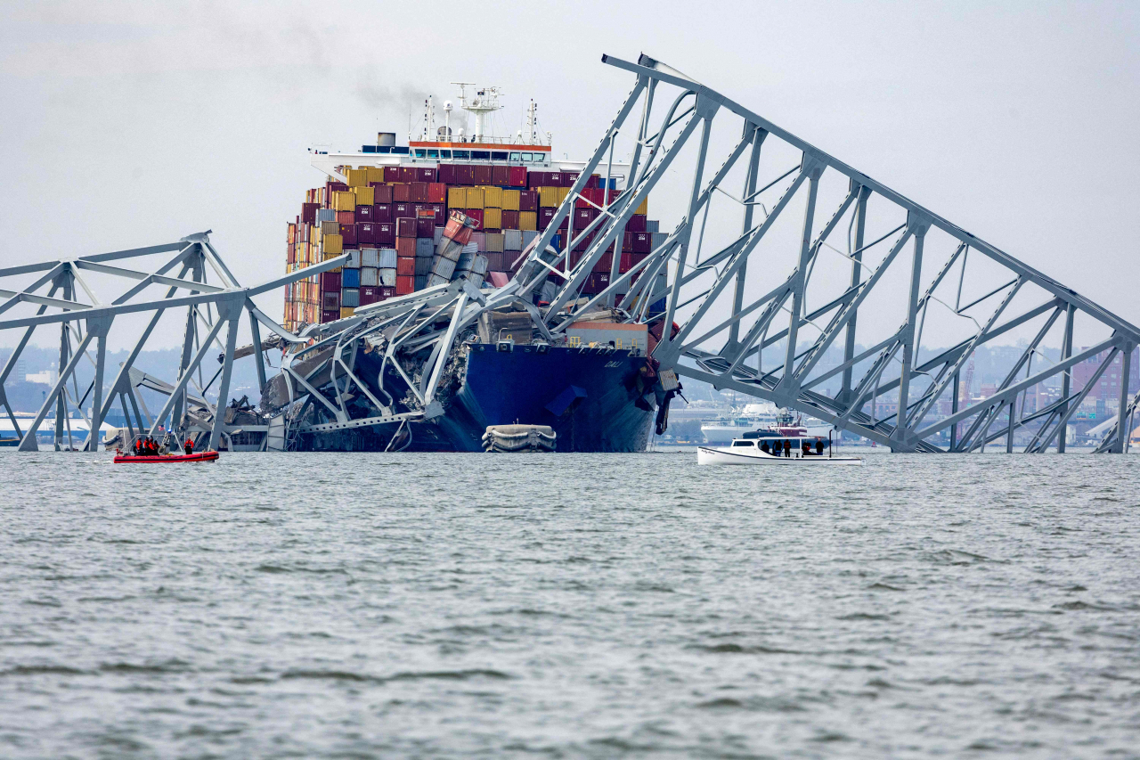 The steel frame of the Francis Scott Key Bridge sits on top of a container ship after the bridge collapsed in Baltimore, Maryland, on Tuesday. (AFP-Yonhap)