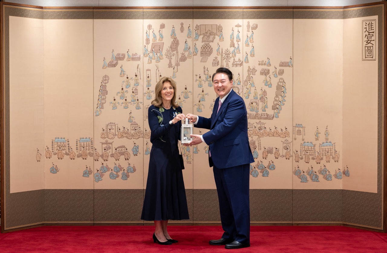 President Yoon Suk Yeol (right) receives the John F. Kennedy Profile in Courage Award from US Ambassador to Australia Caroline Kennedy, the honorary president of the John F. Kennedy Library Foundation, during their meeting at the presidential office, Wednesday. (Yonhap)