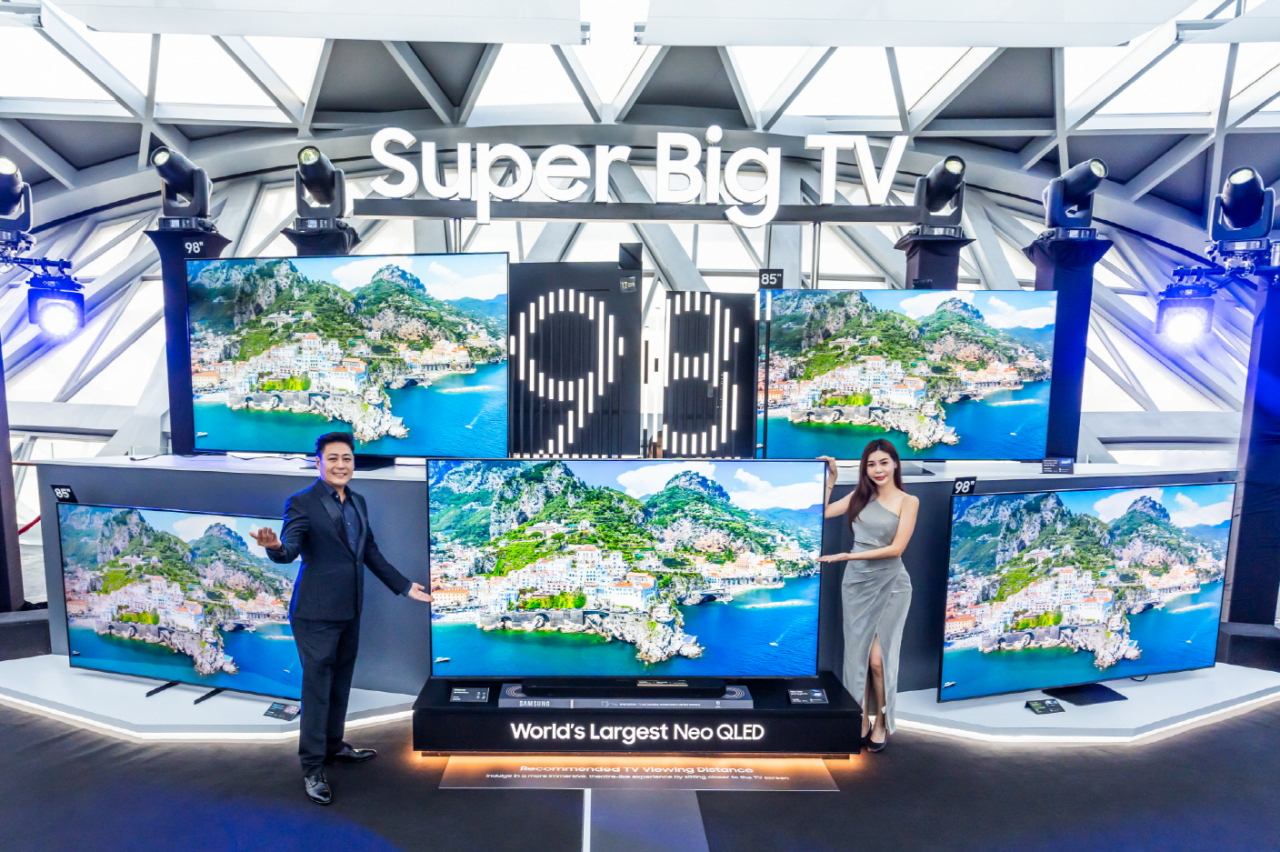 Models pose for photos with Samsung Electronics' newest 98-inch Neo QLED 4K TV at the Korean tech giant's experience zone in Jewel Changi Airport, Singapore. (Samsung Electronics)