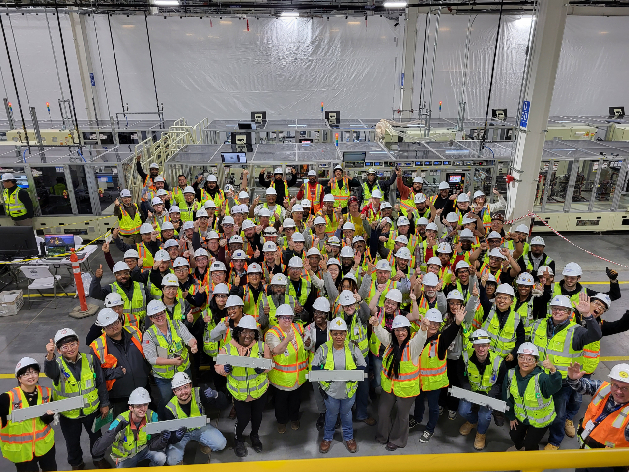 Ultium Cells workers hold the first battery cells produced at its second manufacturing plant in Tennessee. (LG Energy Solution)