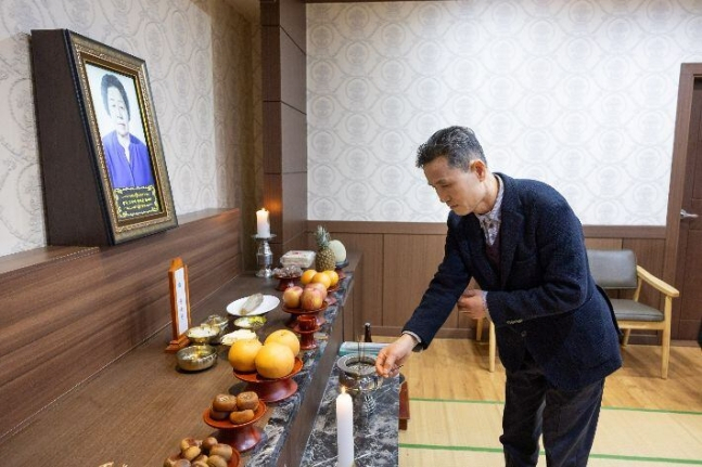 Oh Tae-won, chief of the Buk-gu Office in Busan, pays his respects to the late Gweon Ok-seon at her funeral altar in Buk-gu, Busan, Thursday. (Buk-gu Office)