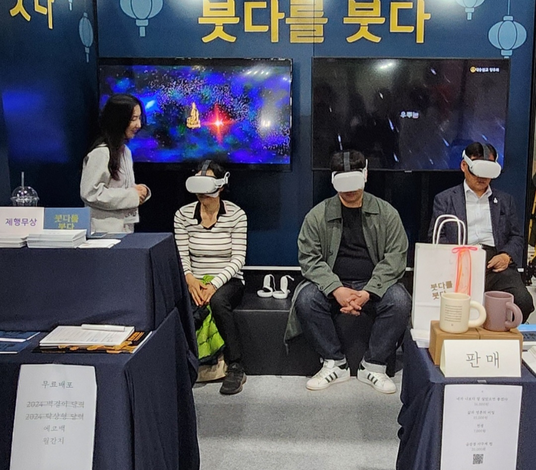 Visitors try on VR headsets playing Buddhist scriptures during the 2024 Seoul International Buddhism Expo at Setec in Seoul on Saturday. (Choi Si-young/The Korea Herald)