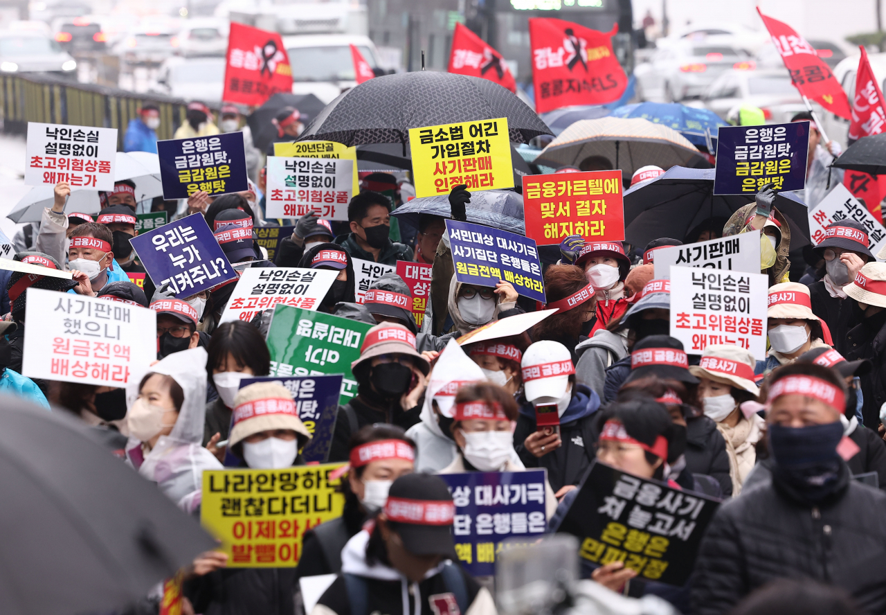 Retail investors hold a protest claiming the sales of equity-linked securities were fraudulent, in front of the headquarters of KB Kookmin Bank in Yeouido, western Seoul, March 29. KB Kookmin Bank was a top seller of the ELS products among local banks. (Yonhap)