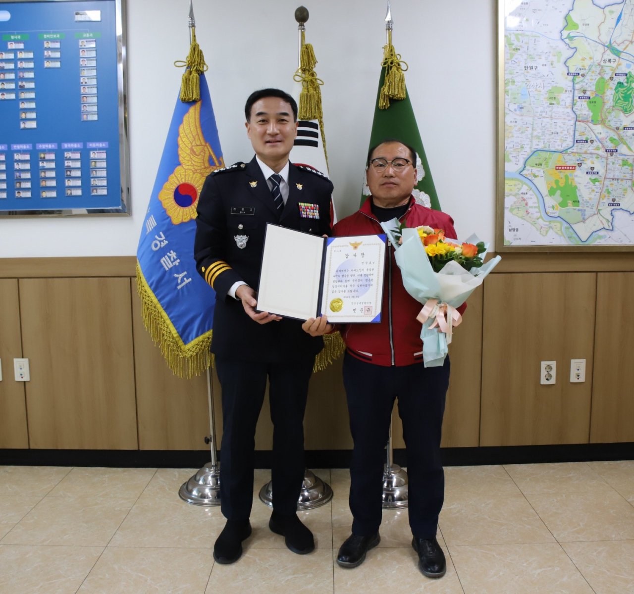 Jeon Jang-pyo (right) receives a certificate of appreciation from Bin Jun-gyu, the chief of Ansan Sangrok Police Station, Tuesday. (Ansan Sangrok Police Station)