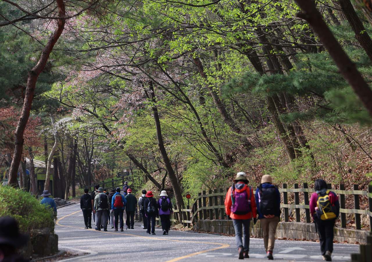 People walk in Gwanaksan in Seoul on Wednesday. The mountain, stretching across southern Seoul and Gyeonggi Province, is famous for its hiking paths that can be approached via multiple subway stations in Seoul, Anyang and Gwancheon. (Yonhap)