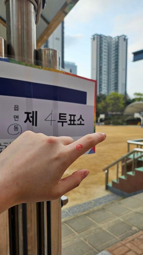 Voter Park Ye-jin, a 24-year-old Seoul resident, takes a photo of her stamped hand. (Park Ye-jin)