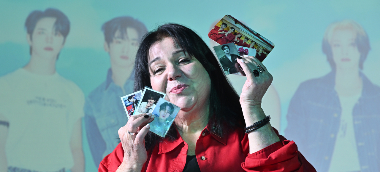 Julia Bellaflores poses for a photo with photo cards of K-pop band WEi after her interview with The Korea Herald on Feb. 7. (Im Se-jun/The Korea Herald)