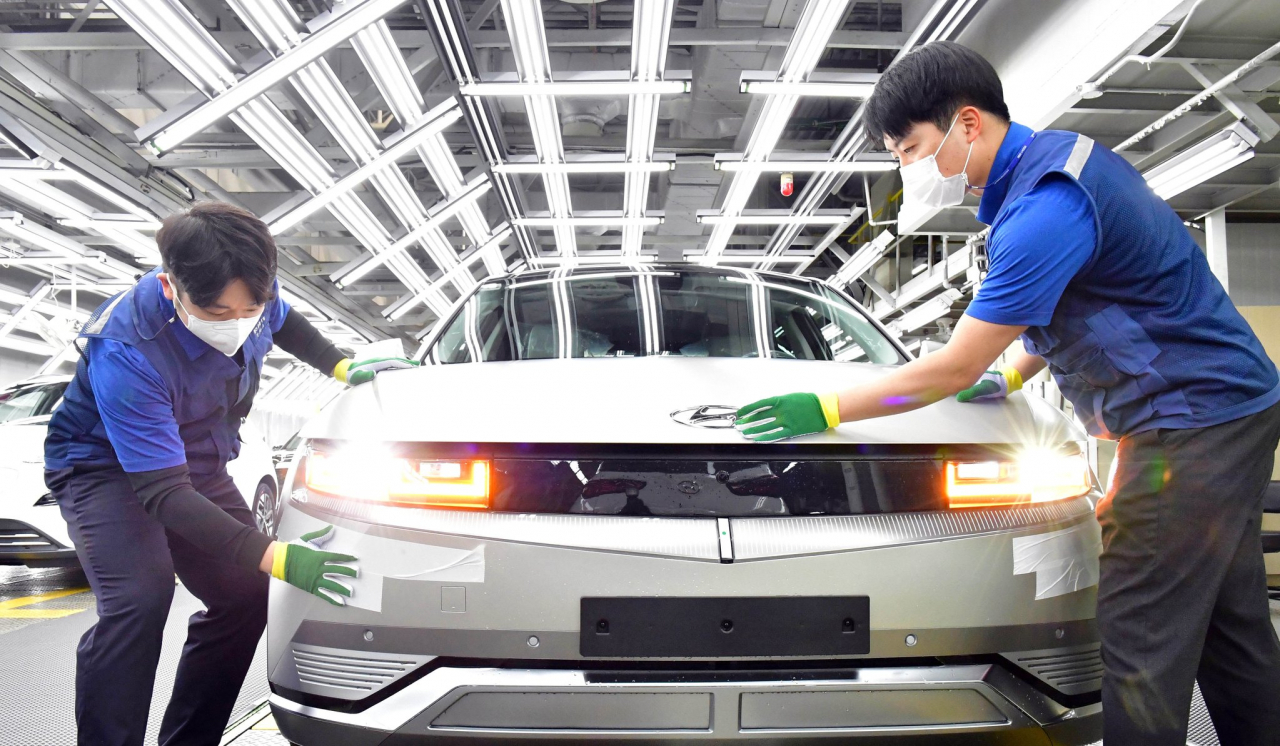 Workers inspect an Ioniq 5 electric vehicle on the production line at Hyundai Motor's Ulsan plant. (Hyundai Motor Group)