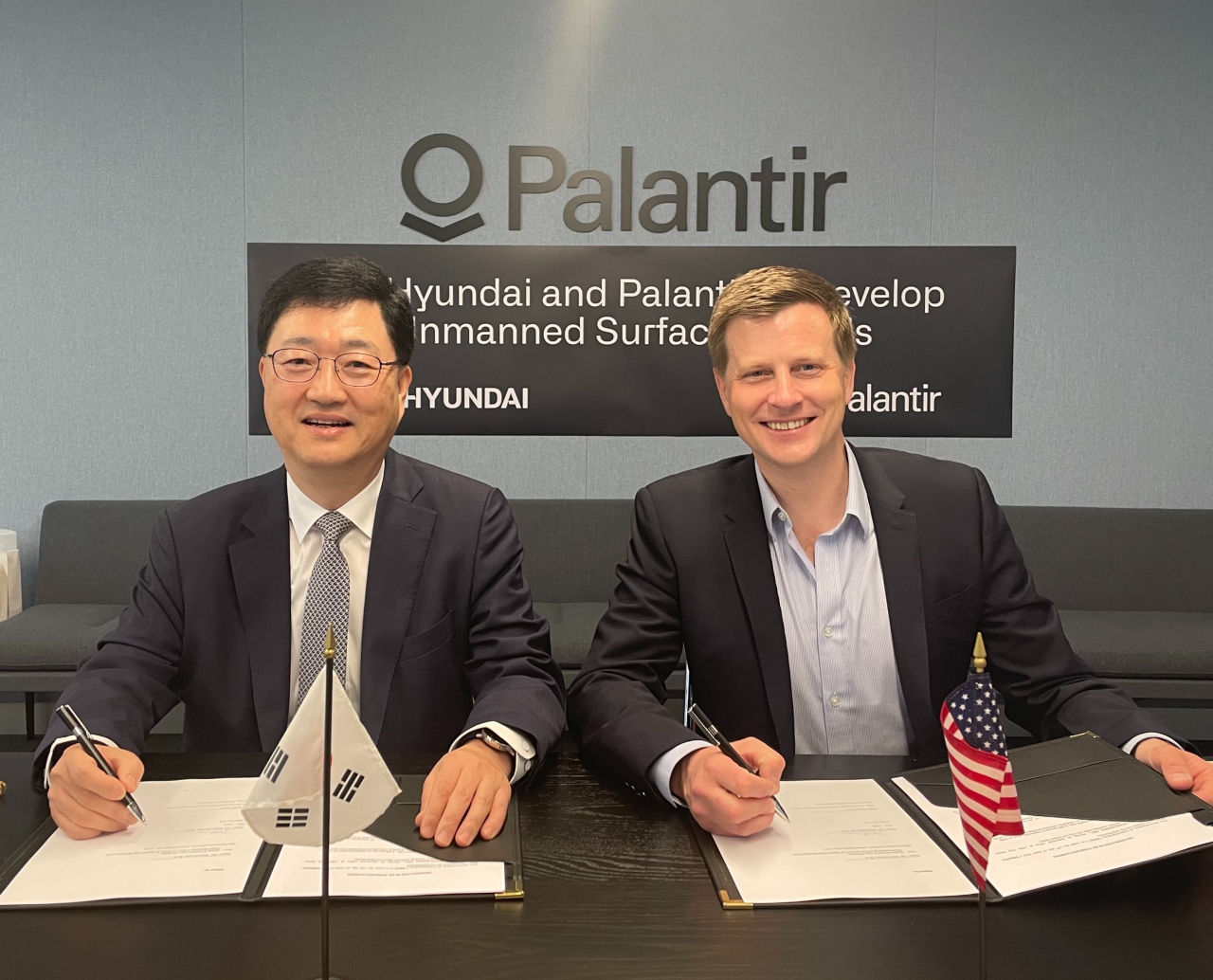Joo Won-ho (left), head of HD Hyundai Heavy Industries' special ship business unit, and Ryan Taylor, chief revenue officer and chief legal officer at Palantir Technologies, sign a memorandum of understanding for joint development of uncrewed surface vessel in Washington, DC, Thursday. (HD Hyundai)