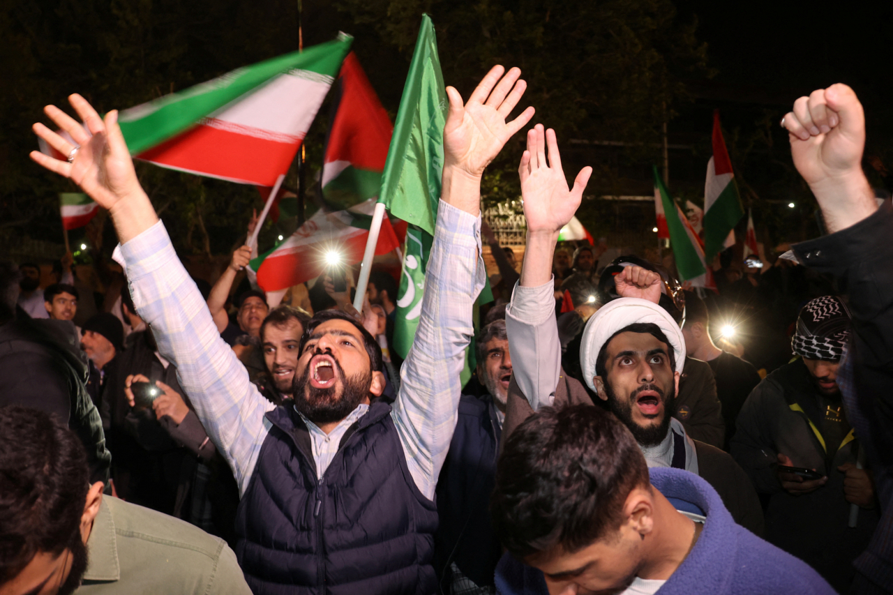 Iranian demonstrators react after the IRGC attack on Israel, during an anti-Israeli gathering in front of the British Embassy in Tehran, Iran, Sunday. (West Asia News Agency-Reuters)