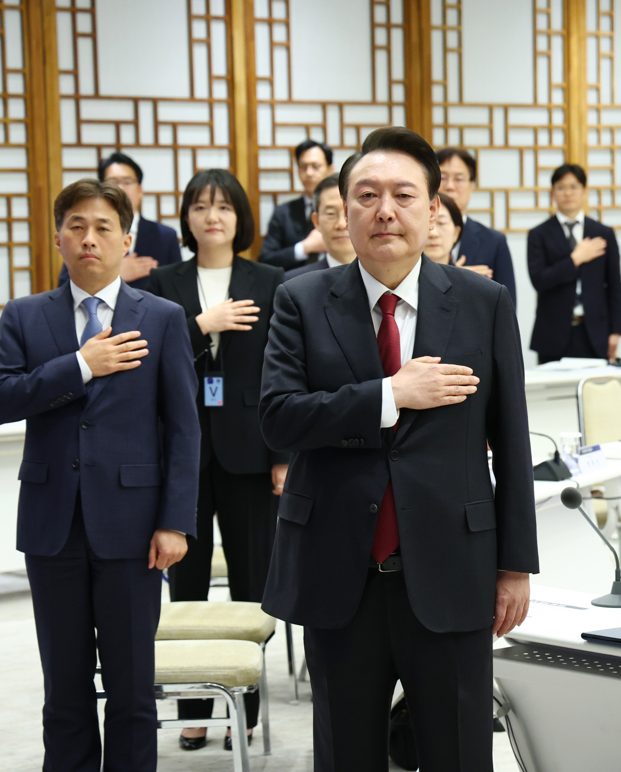 President Yoon Suk Yeol (right, front row) salutes to the national flag as he presided over a meeting with semiconductor industry leaders at his office in Seoul on April 9. (Pool photo via Yonhap)