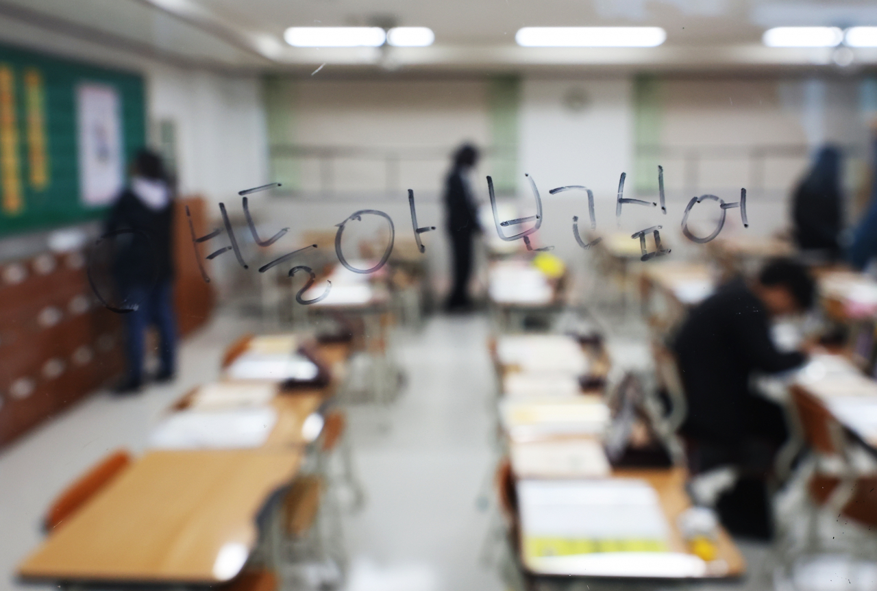 People visit the 4.16 Memorial Classroom at Danwon High School in Ansan, Monday, to pay their respects to the victims of the sinking of the Sewol ferry on April 16, 2014. The text written on the classroom window reads: 