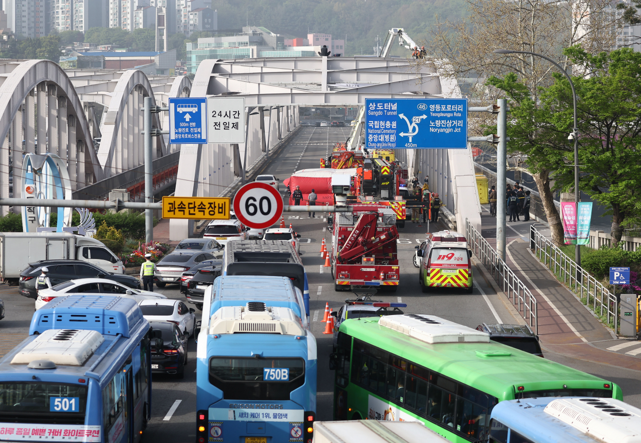 This photo taken Wednesday morning shows traffic built up at the entrance of the Hangangdaegyo bridge in Seoul, due to lanes being closed after a man climbed on top of the bridge and staged a protest. (Yonhap)