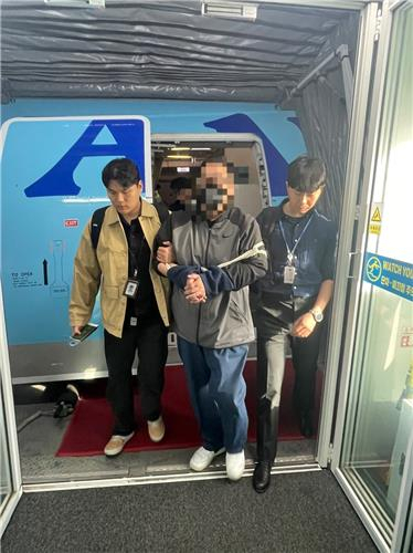 A man in custody arrives at Incheon International Airport, west of Seoul on Wednesday. (National Police Agency)