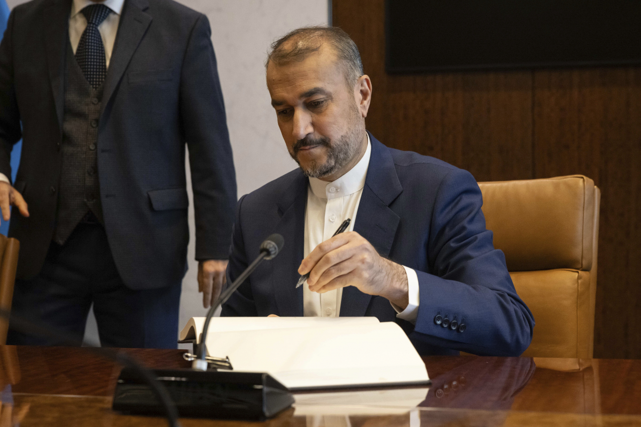 Iran's Foreign Minister Hossein Amir-Abdollahian signs a visitor's book before a meeting with United Nations Secretary-General Antonio Guterres at United Nations headquarters, Thursday. (AP-Yonhap)