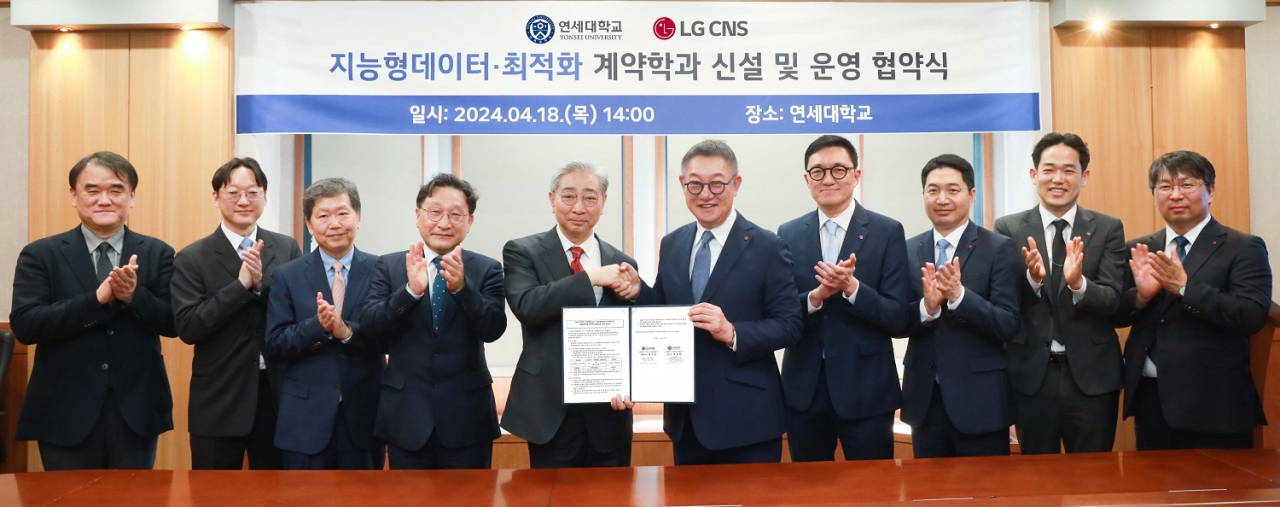 LG CNS CEO Hyun Shin-gyoon (center right), Yonsei University President Yoon Dong-sup (center left), and other officials pose for a photo after signing an agreement to jointly establish an academic department at Yonsei University's Underwood Hall, Thursday. (LG CNS)