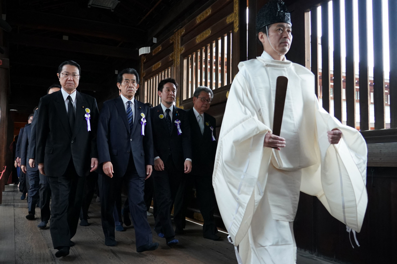 A Shinto priest leads Japanese lawmakers during a visit to the controversial Yasukuni Shrine at the end of the spring festival, in Tokyo on Tuesday. (AFP)
