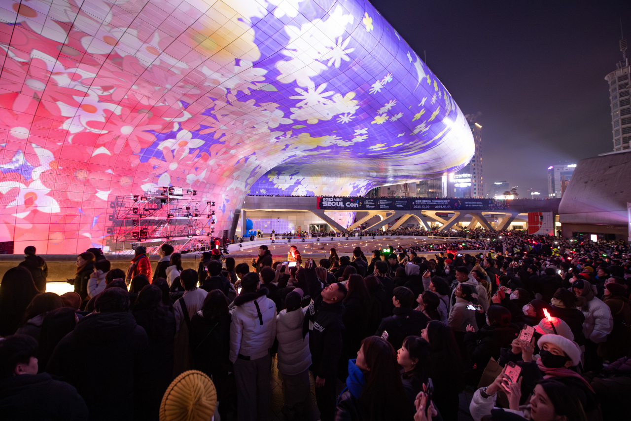 A crowd watches a media display projected onto the Dongdaemun Design Plaza during a New Year's Eve countdown event on Dec. 31, 2023. (Seoul Design Foundation)