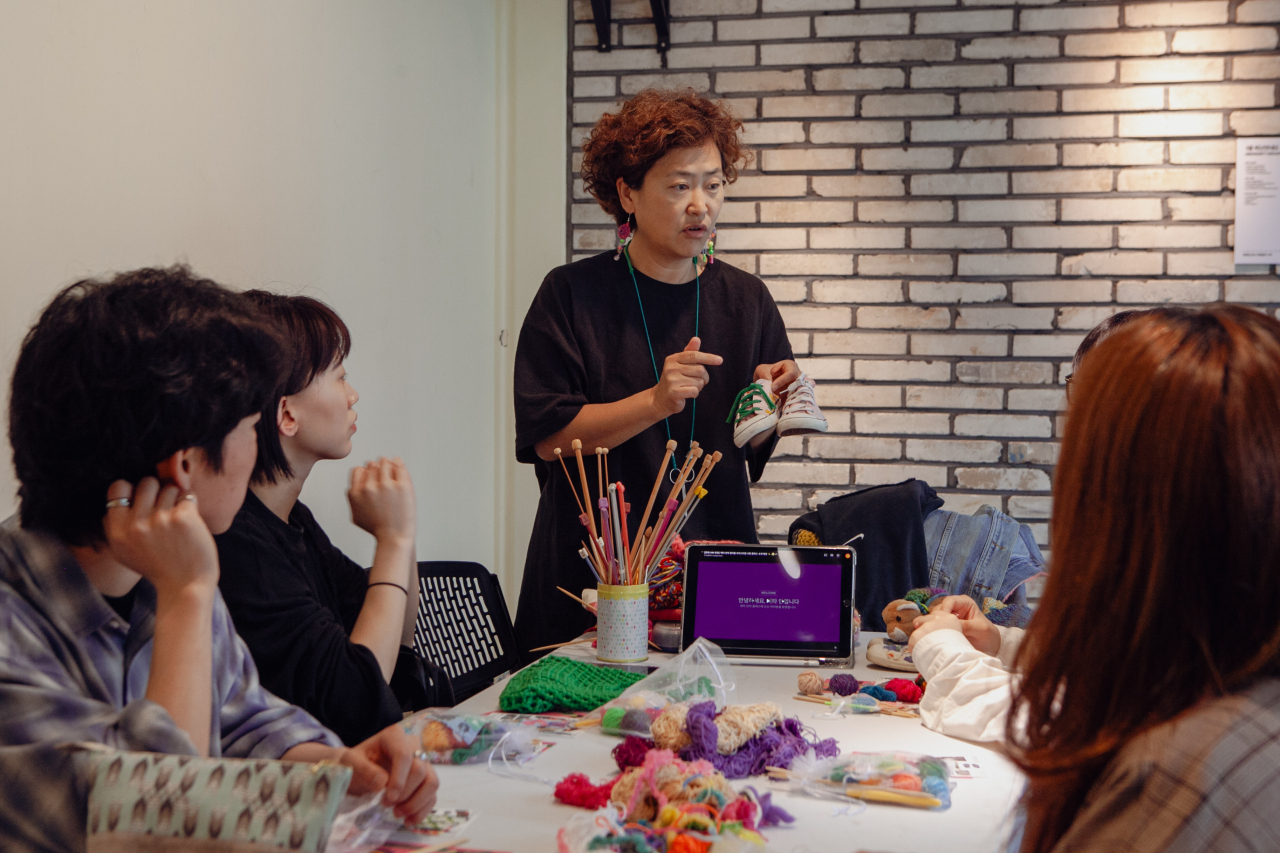 Participants learn how to knit at a 21% Party's workshop held in Seongsu-dong, Seoul, April 20, 2024. (Wear Again Lab)